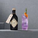 Illusionist Dry Gin Bottle and Pink Gin Cocktail in a Glass